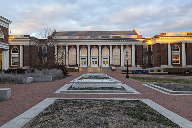 External photo of columned building with symmetrical brick walkways in front