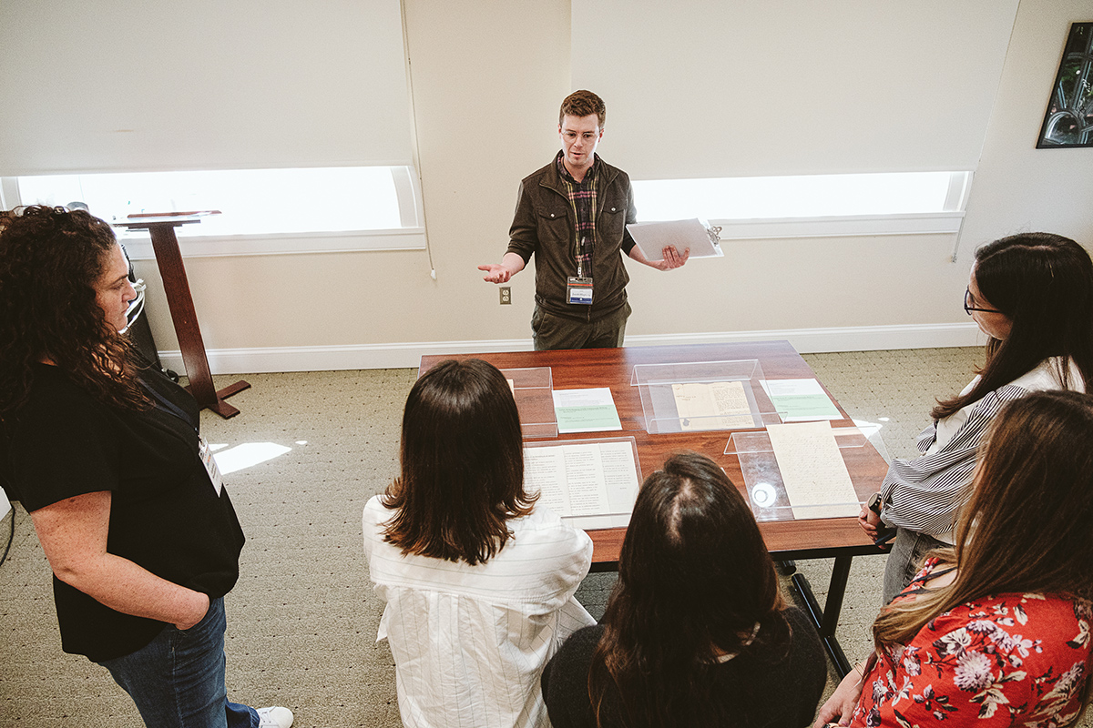 A librarian shares original letters written by Simón and Fernando Bolivar with a group of people.