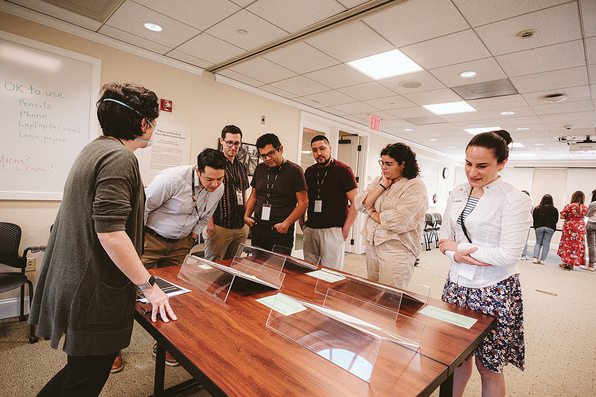 A librarian shows people papers from the founding of the Bolívar Network, an organization of Latinx and Hispanic alumni.