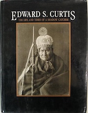 Cover of the book "Edward S. Curtis: The Life and Times of a Shadow Catcher," featuring a portrait of a Native American in traditional attire with a feathered headdress and holding a spear.
