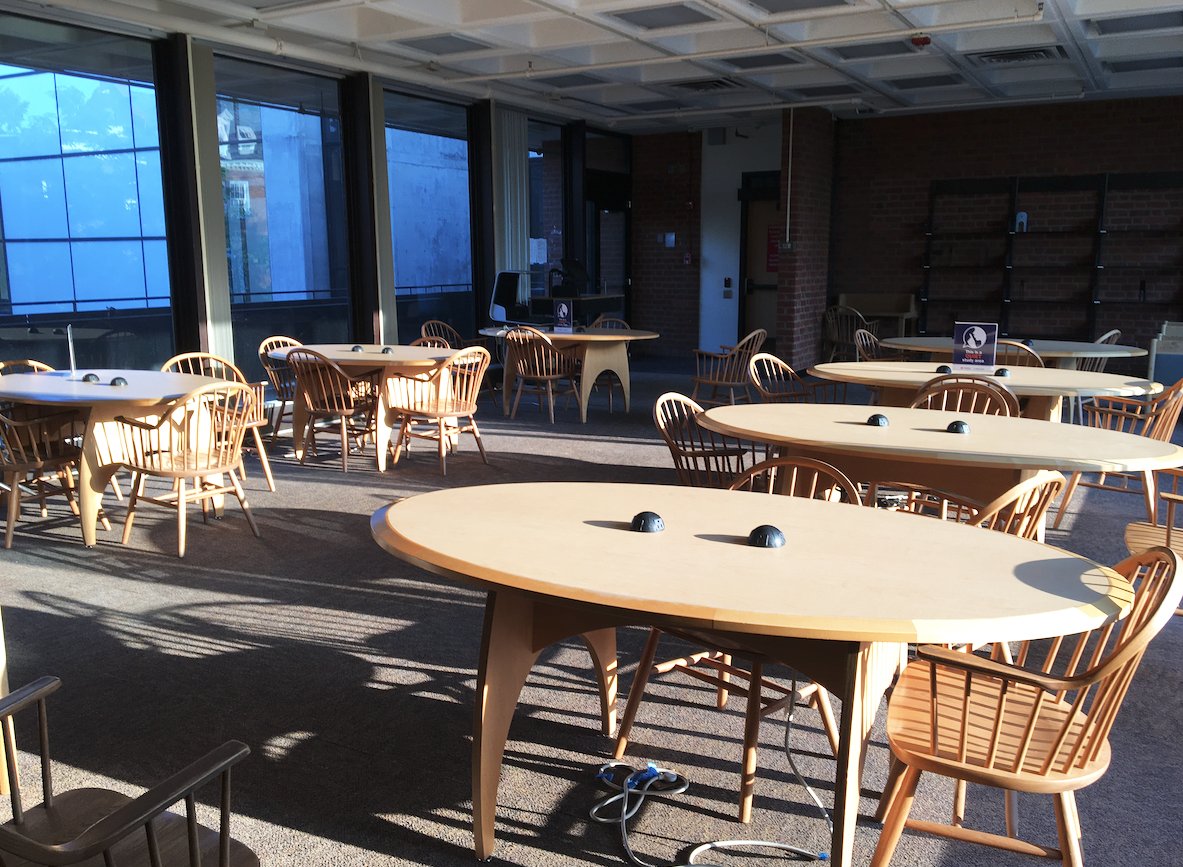 Sunlight spills over chairs and oval tables.