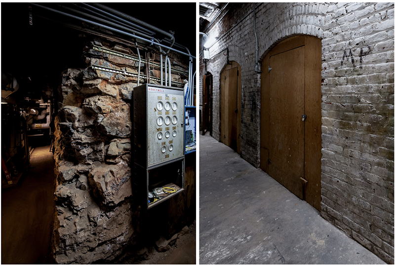 A split image of two sections of an old, dimly lit basement or utility area. The left side shows a rugged stone wall with an old Honeywell electrical panel mounted on it, surrounded by exposed pipes and wiring. The right side depicts a long brick corridor with wooden doors and metal fixtures, illuminated by overhead lights. The corridor has an aged, industrial feel, with exposed bricks and some graffiti on the wall. The scene has a slightly eerie and abandoned atmosphere.