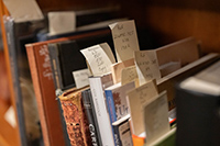 A shelf of books, each with a handwritten bookmark